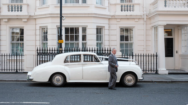 London. Mann vor einem weissen Auto